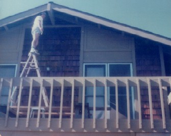 1970s - dad up a ladder on balcony above garage.